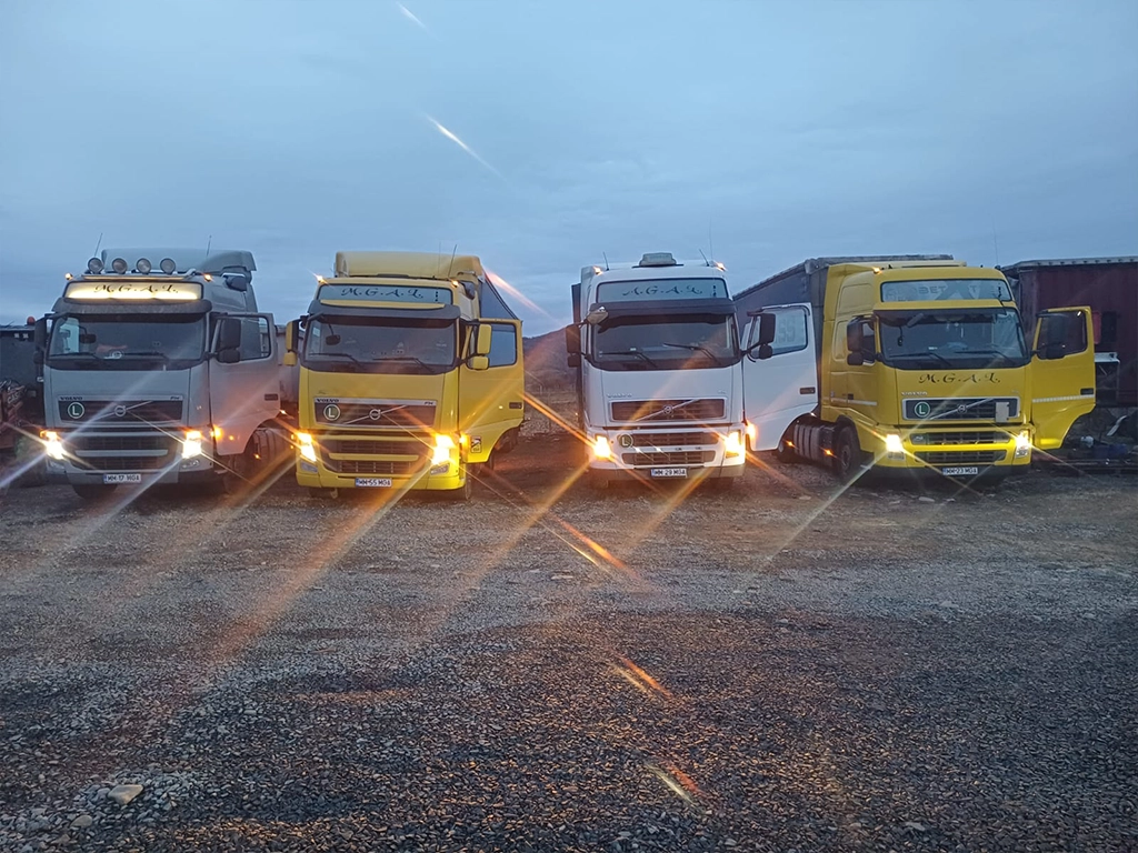 Camioanele firmei MGAL parcate la garaj si fotografiate cu luminile aprinse